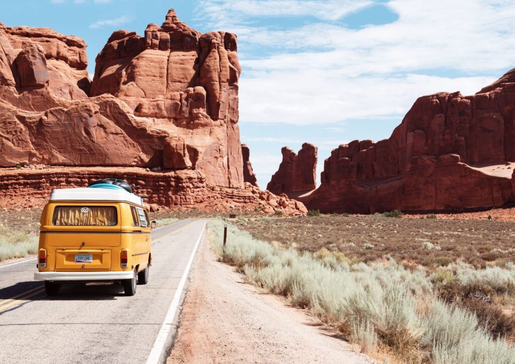 Eat, Move, Make, Fitness, Travel - An orange van travels down a remote desert highway.